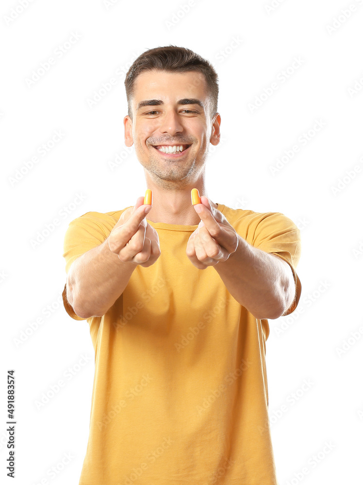 Smiling young man with earplugs on white background