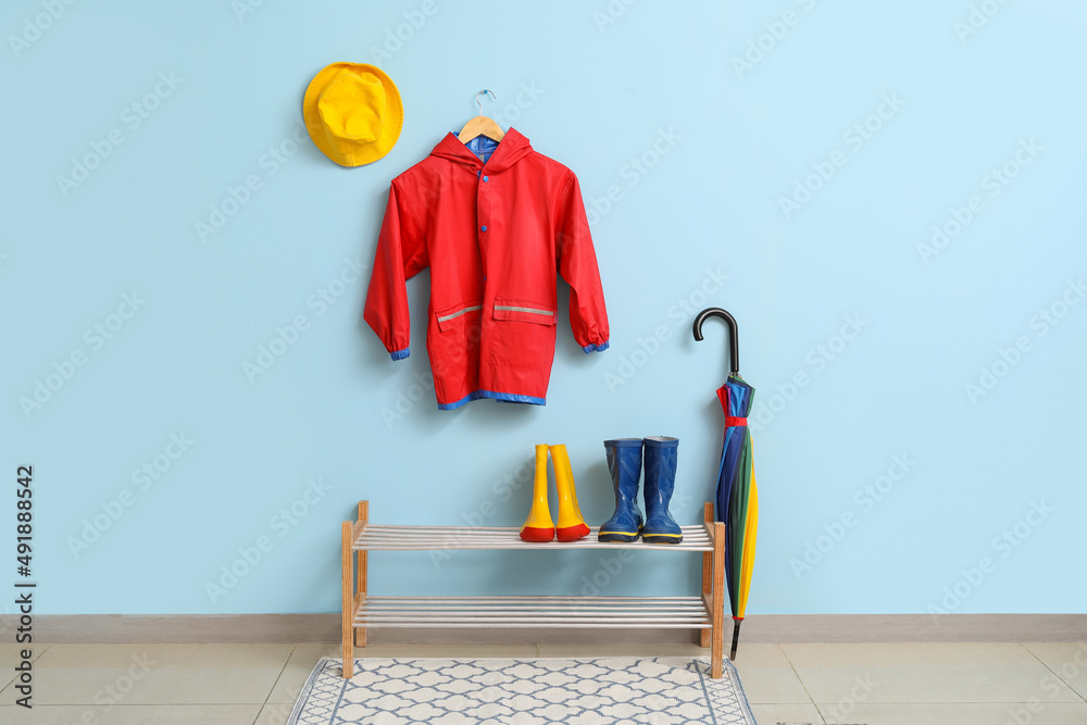 Interior of hallway with childs raincoat, gumboots, hat and umbrella