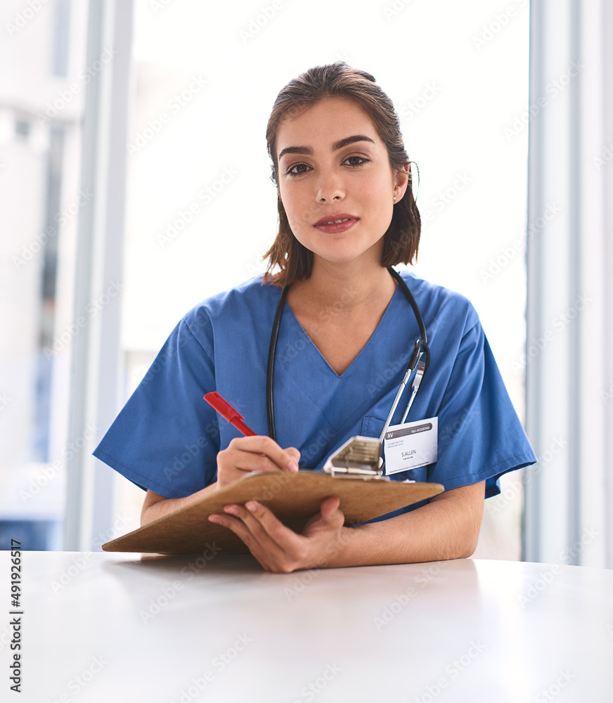 She is dedicated to her career. Portrait of a confident young female doctor making notes on a clipbo