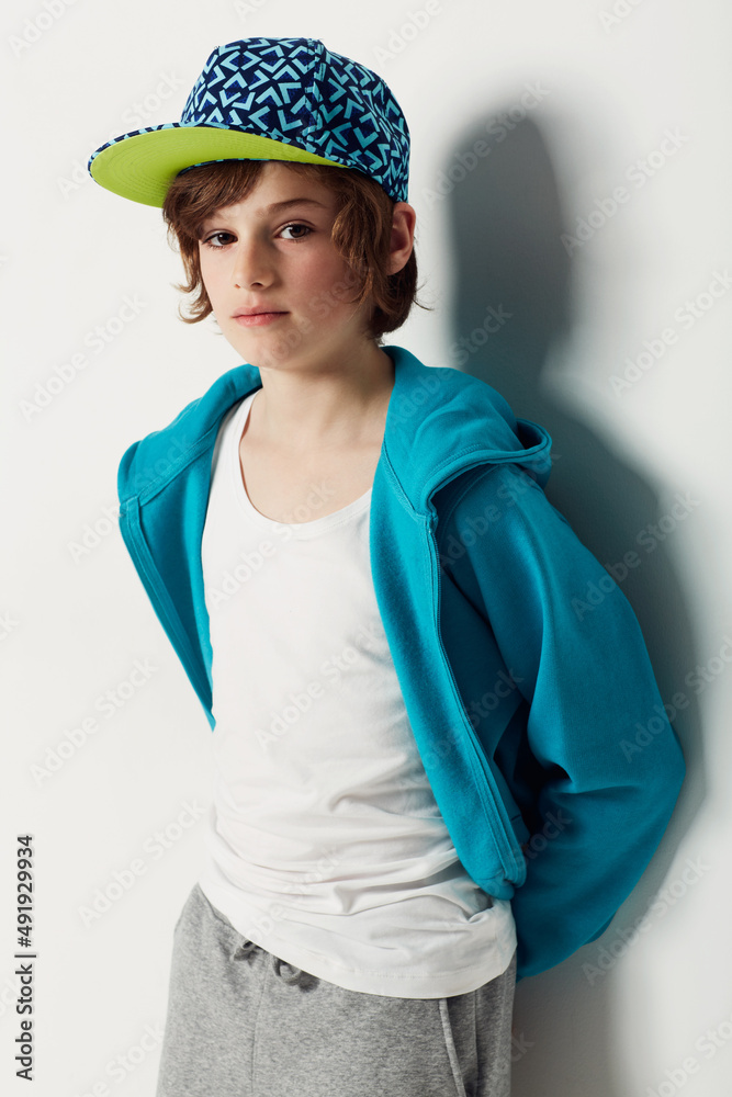 Moody blue. Cute preteen boy wearing trendy clothing while isolated on white.