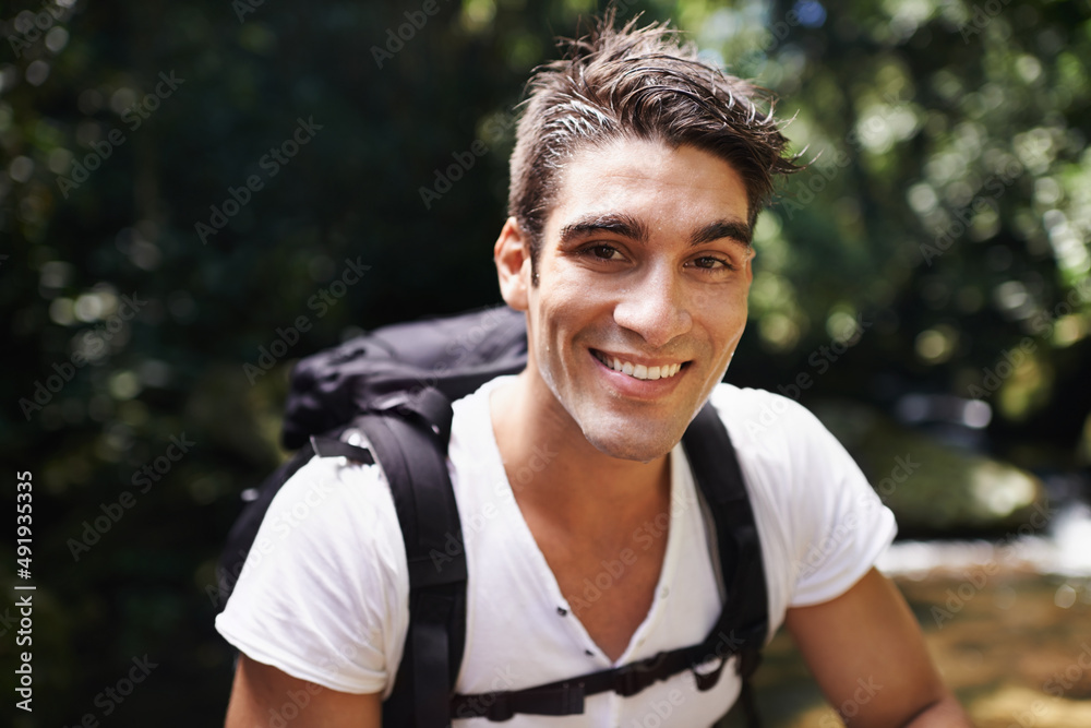 Getting away from it all. Shot of a handsome young man hiking in the forest.