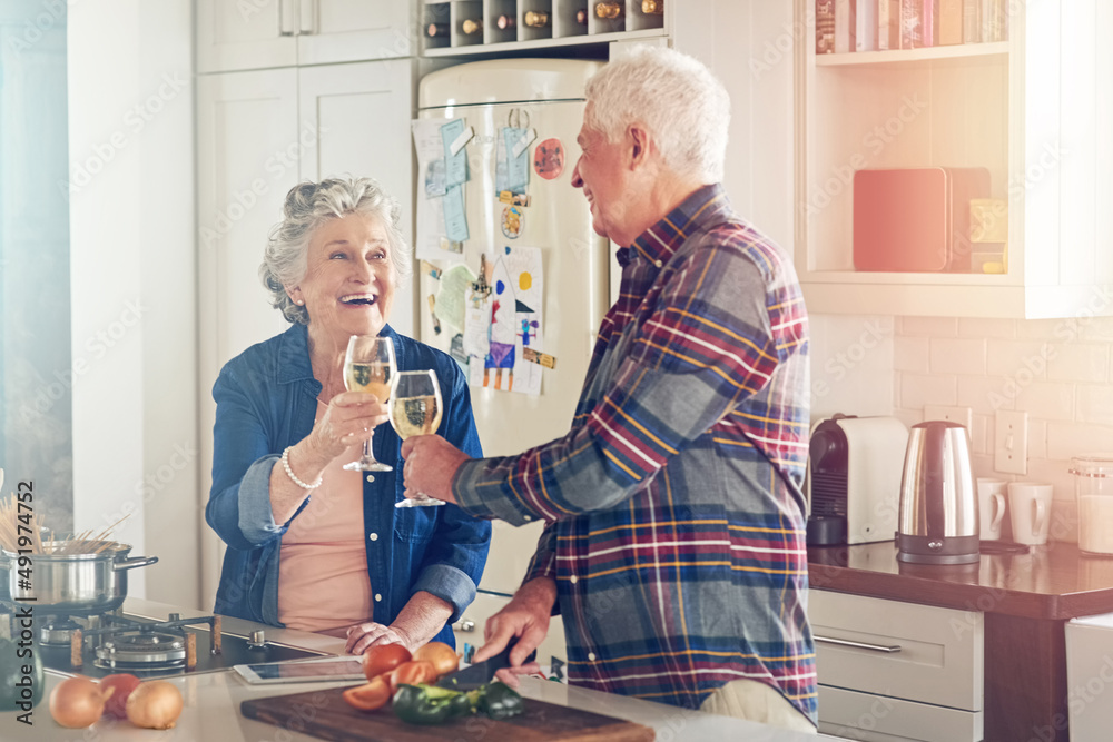 Heres to our perfect lifetime together. Shot of a smiling senior couple cooking together in their ki