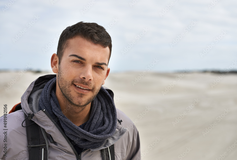 没有气候太多了。一位年轻的男性徒步旅行者沿着沙丘行走的肖像。