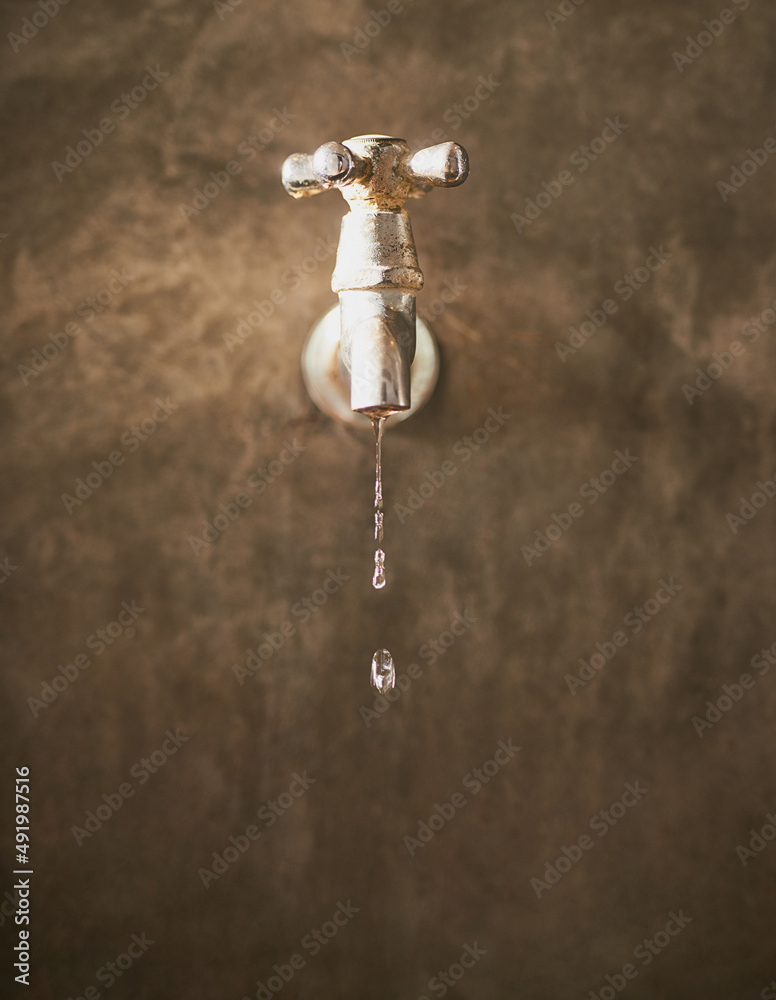 Conserve every drop you can. Cropped closeup shot of a tap dripping water.