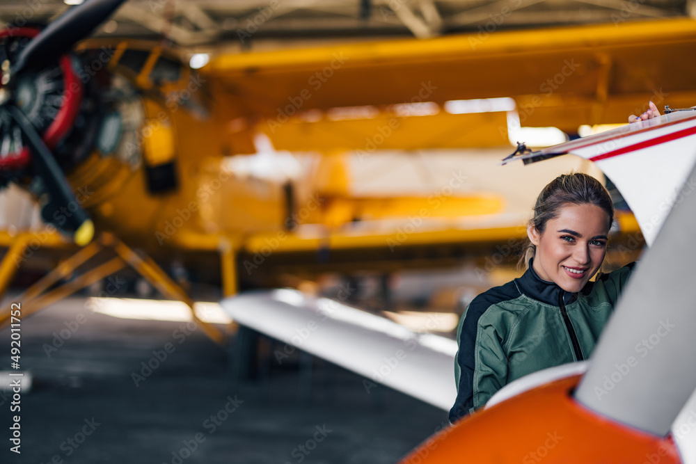 Portrait of female aviator, smiling for the photo.