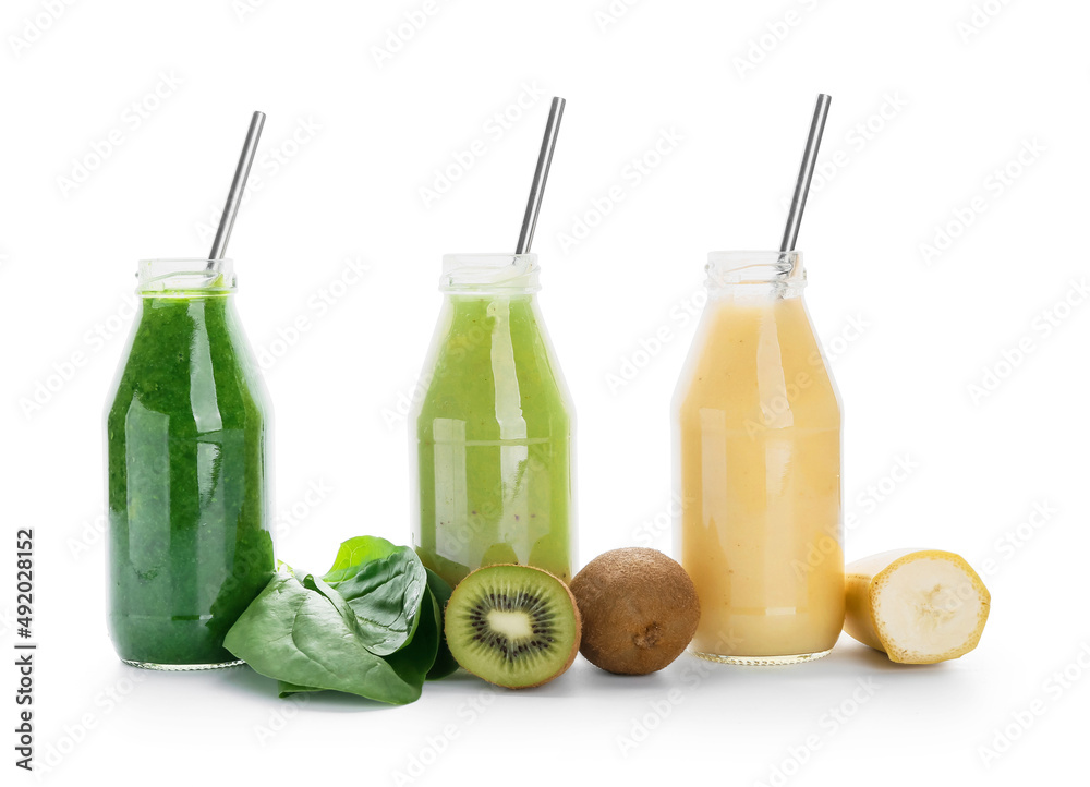 Bottles of healthy smoothie and fruits on white background