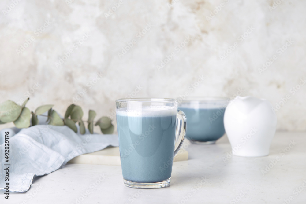 Glass cup of delicious Charcoal Latte on light table