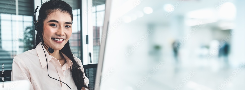 Businesswoman wearing headset working actively in office . Call center, telemarketing, customer supp