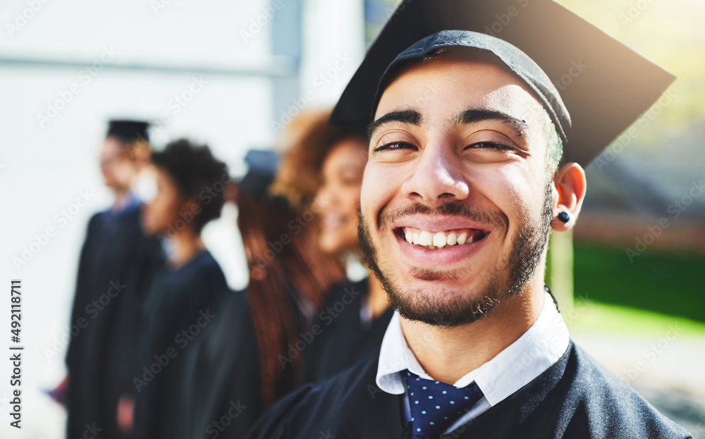 我今天让我的家人感到骄傲。一个微笑的大学生在毕业典礼上与同学合影