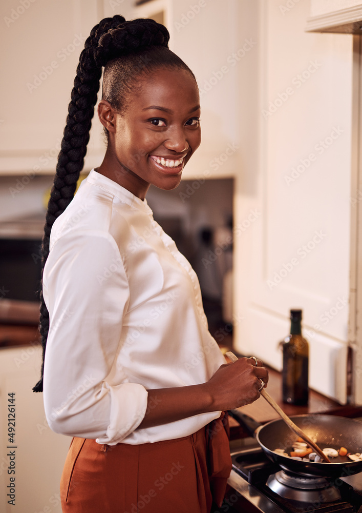 Im making my favourite. Cropped portrait of an attractive young woman cooking in her kitchen at home