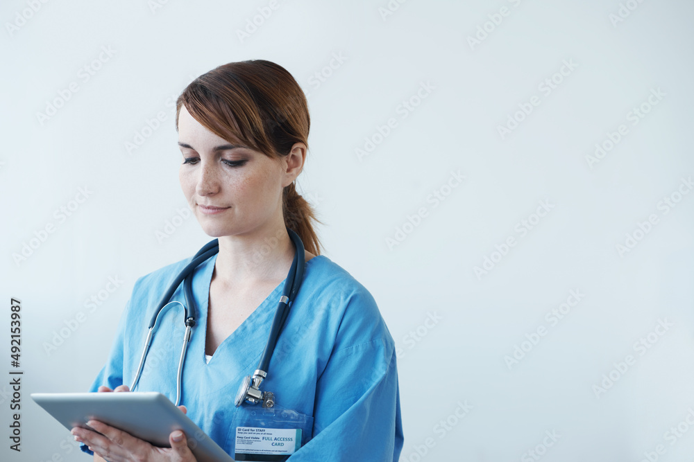 Diagnosing patients using digital tools. A female doctor working on a digital tablet.