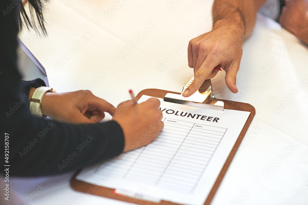 Every little bit helps. Cropped shot of volunteer getting signatures for church donations.