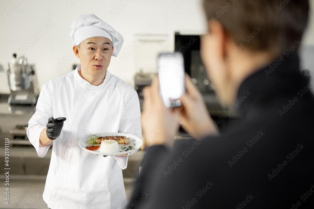 身着制服的亚洲厨师一边谈论烹饪菜肴，一边用专业ki维护烹饪博客