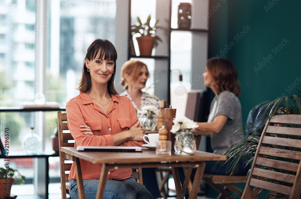 我每天都来这里。一位迷人的中年女性独自在咖啡馆喝咖啡的肖像