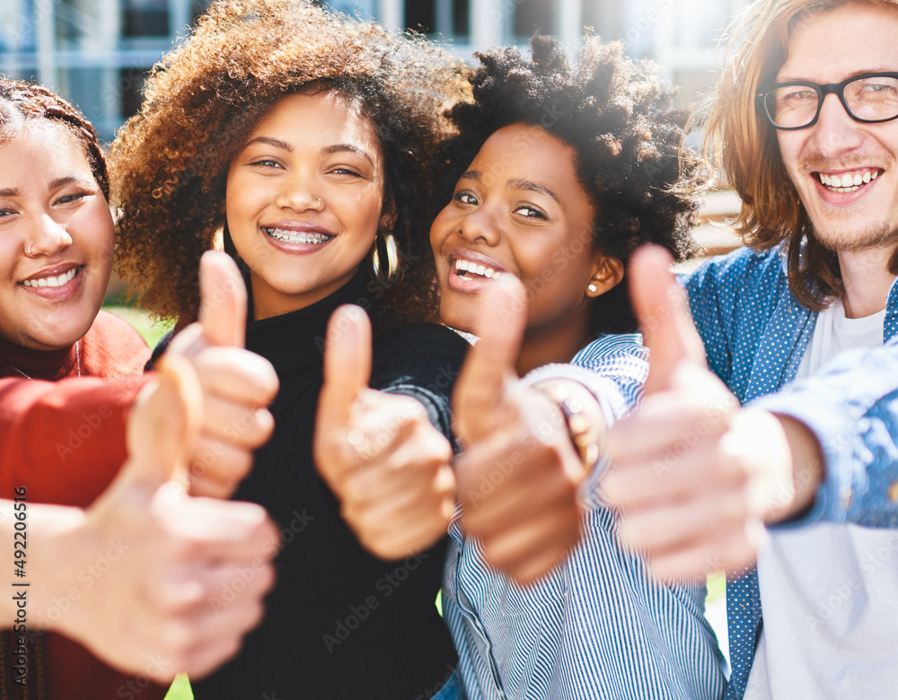 Youve got our vote. Cropped portrait of a diverse group of college friends giving thumbs up while st