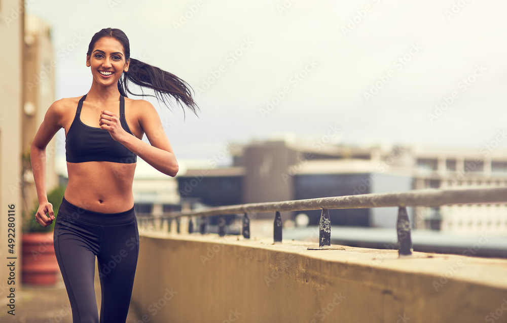 We are designed to move. Shot of a beautiful young woman exercising outdoors.