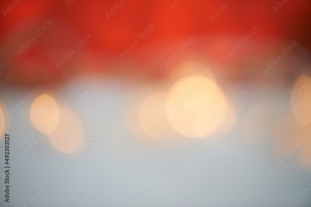 Bright lights, beautiful holiday. Bokeh lights against a red and grey background.