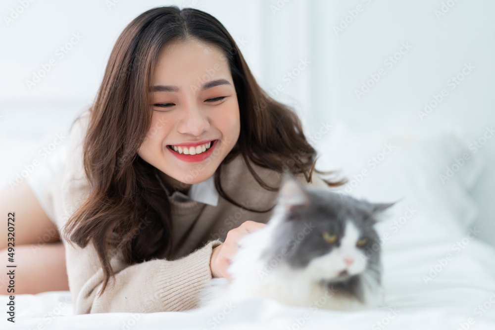 年轻的亚洲女人在家玩猫