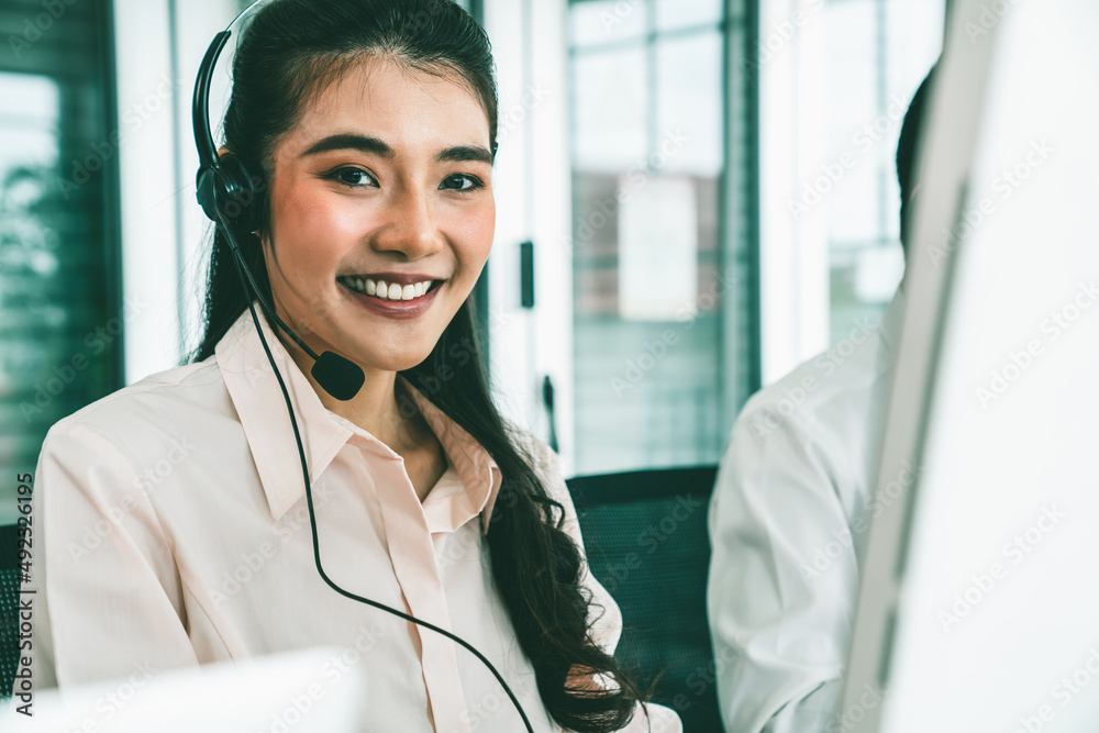 Businesswoman wearing headset working actively in office . Call center, telemarketing, customer supp