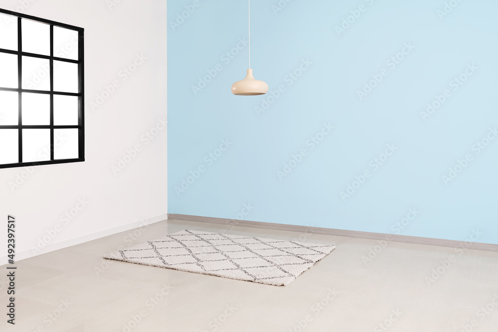 Stylish carpet and lamp hanging in big empty room