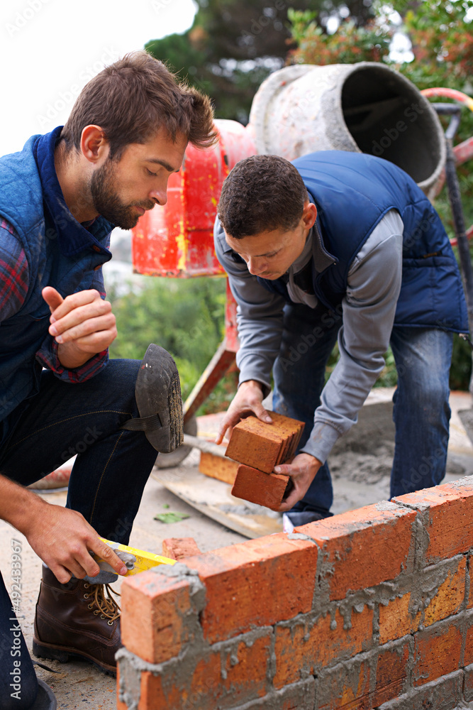 Making strong foundations together. Shot of bricklayers at work.