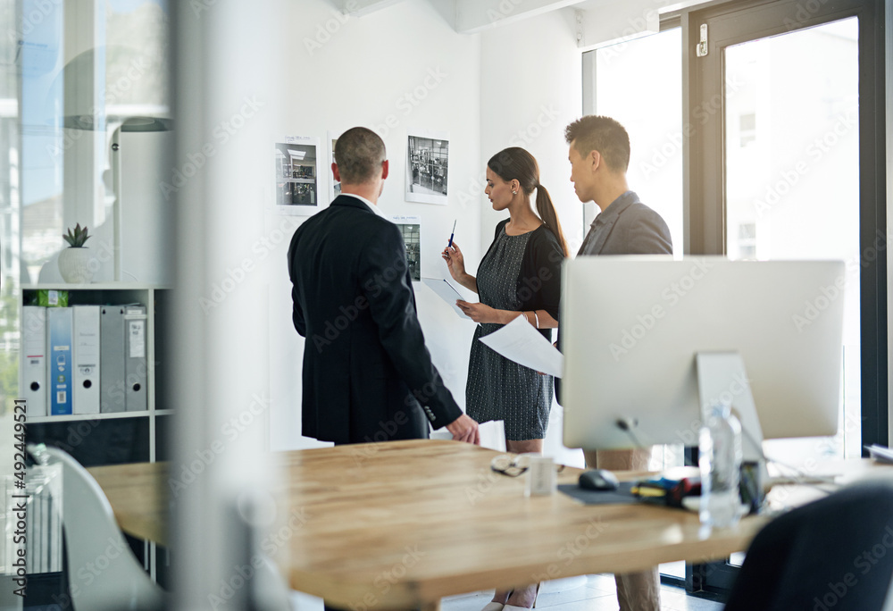 Going over their strategy. Cropped shot of three colleagues working in the office.