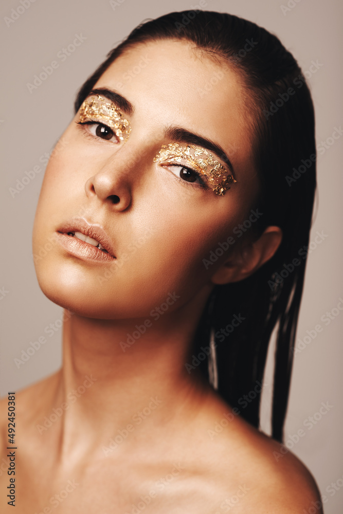 All that glitters. Portrait of an attractive brunette with golden flakes around her eyes.