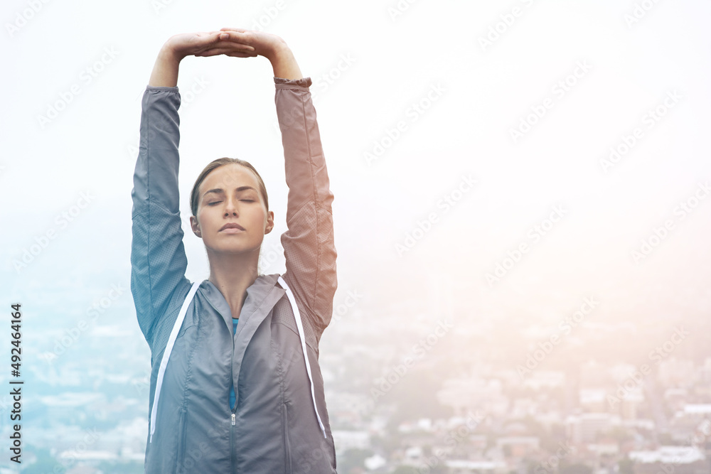 Adventure is not outdoors, its within. Shot of a young woman stretching before a morning run.