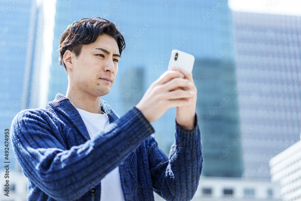 野外でスマートフォンを使う男性