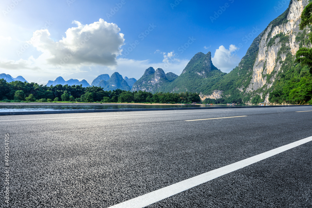 夏日蓝天下的沥青公路和山地自然风光。公路和山地背景。