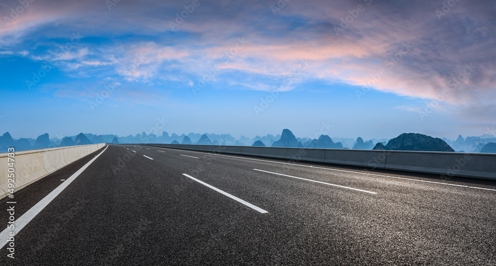 日落时的沥青公路和山脉自然风光。道路和山脉背景。