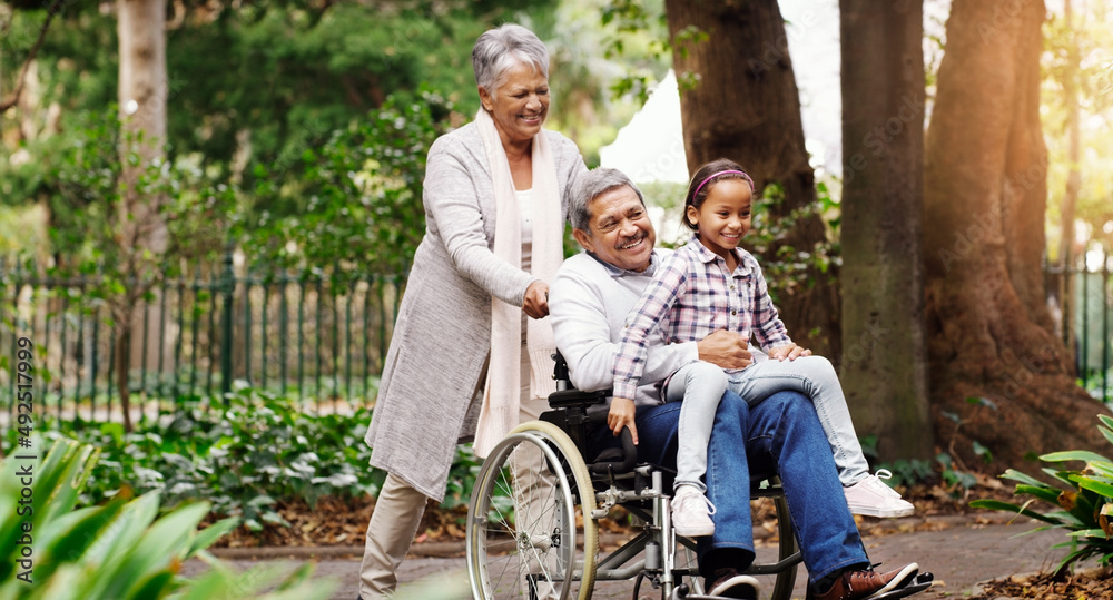 Taking a ride through the park. Shot of an adorable little girl playing with her grandparents at the