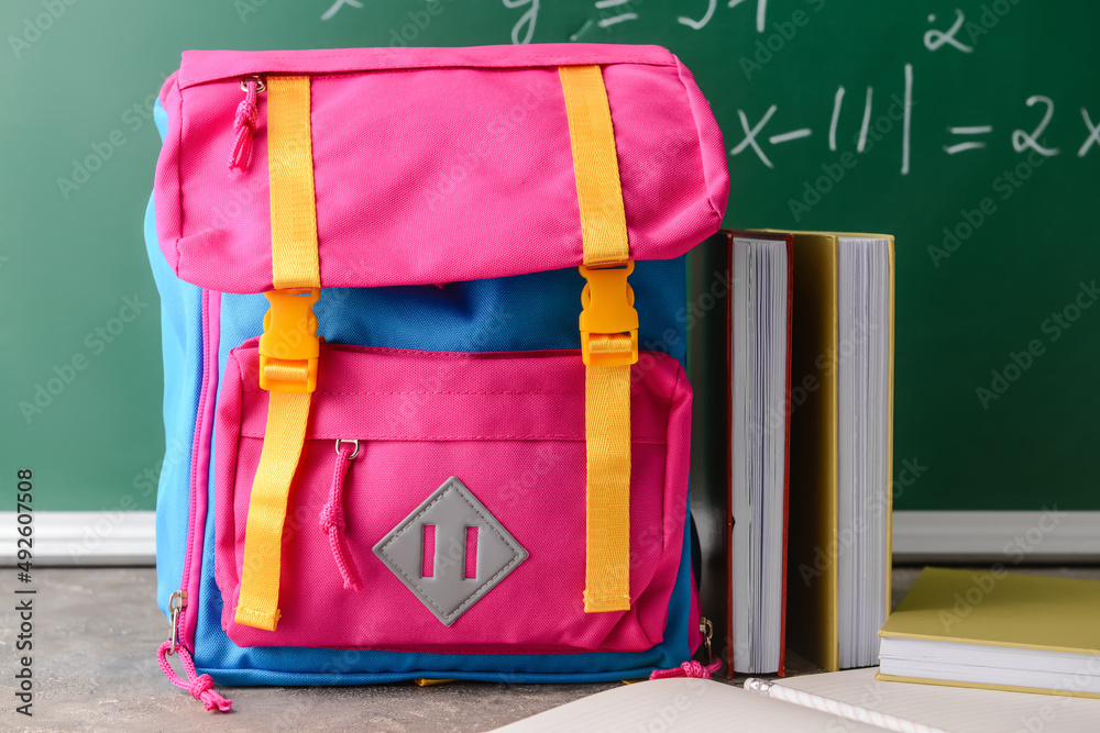 School backpack and notebooks on table in classroom on table in classroom