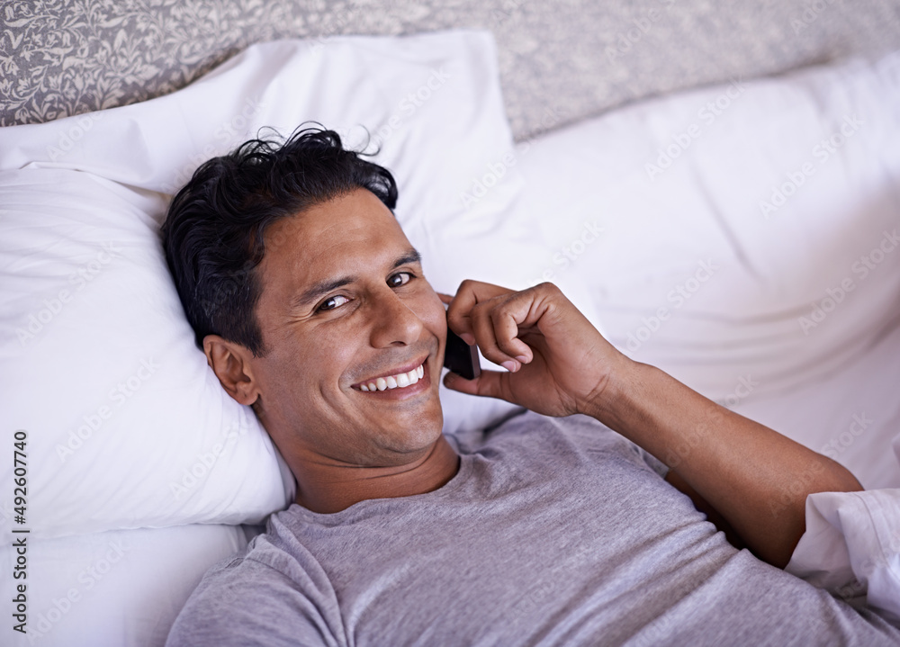 The comforts of technology. Shot of a handsome young man trying to get some rest in bed.