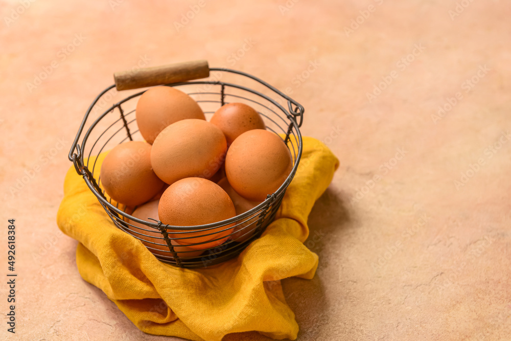 Basket with fresh chicken eggs on beige background