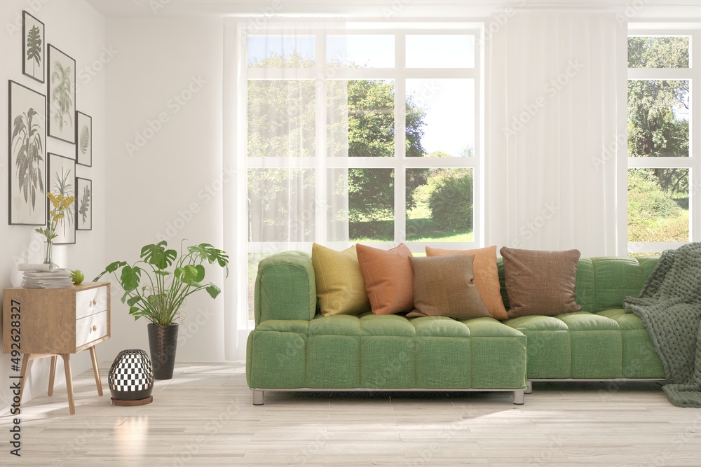 Minimalist living room in white color with sofa and summer landscape in window. Scandinavian interio