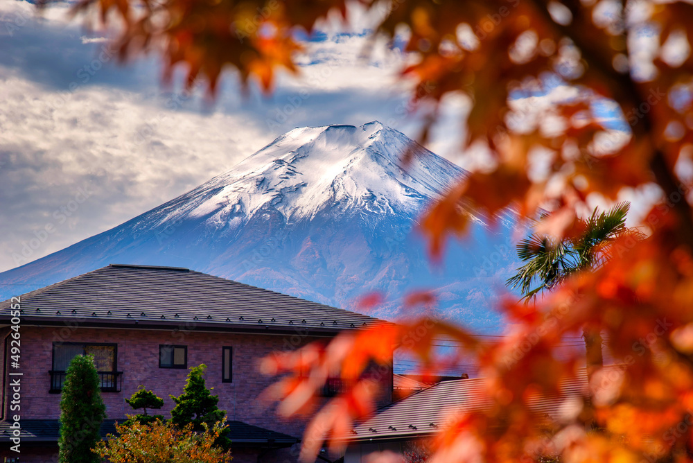 Mt. Fuji behind house with autumn foliage at sunset in Fujikawaguchiko, Japan.