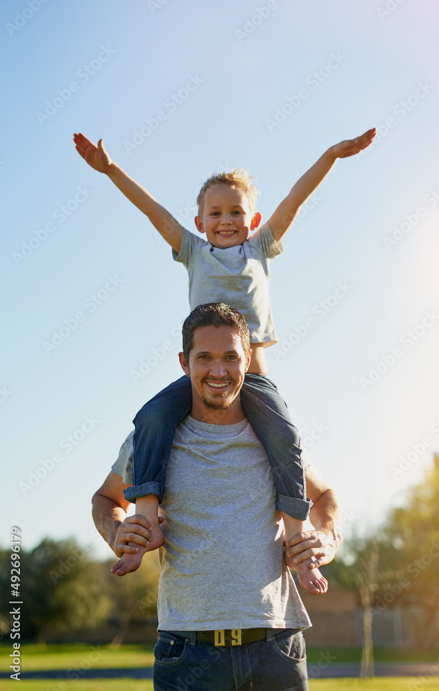 Days with dad are just the best. Shot of a father carrying his little son on his shoulders while enj