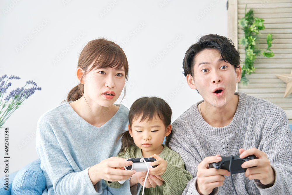 テレビゲームで遊ぶ家族