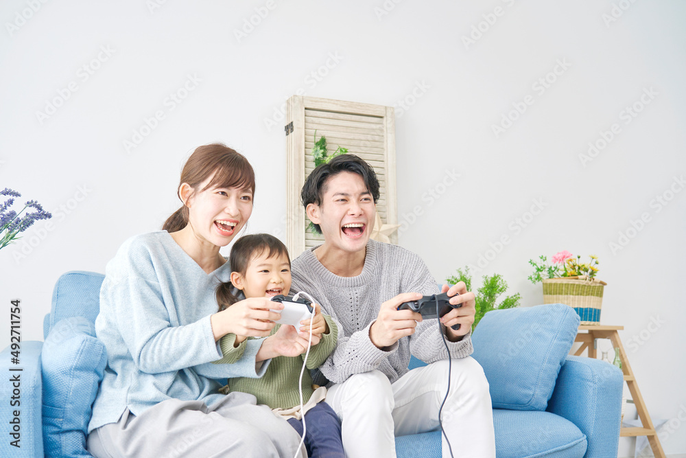 テレビゲームで遊ぶ家族