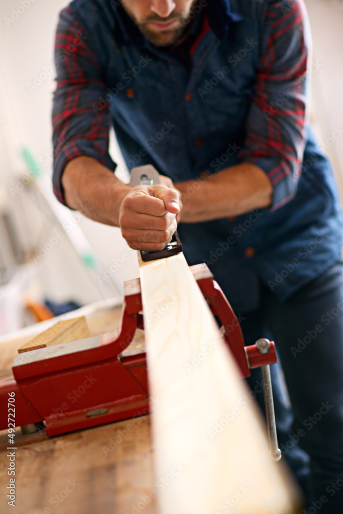 Precision and perfection. Shot of a handsome young carpenter measuring a piece of wood.