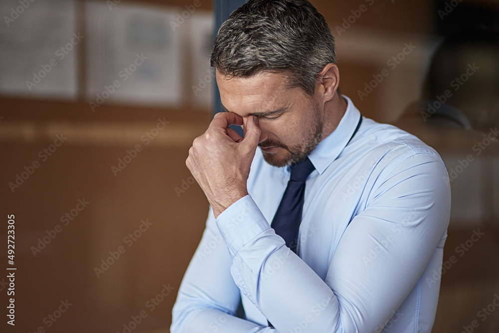 Lots to do but no time to do it. Cropped shot of a mature businessman looking anxious while working 