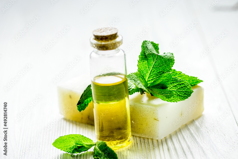 herbal extract in glass bottles with mint on wooden table background