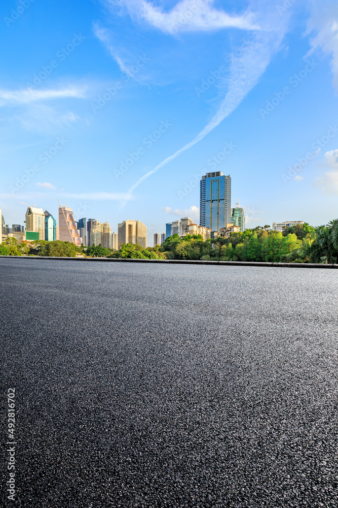 Asphalt road platform and city skyline with modern commercial buildings in Shenzhen, China.