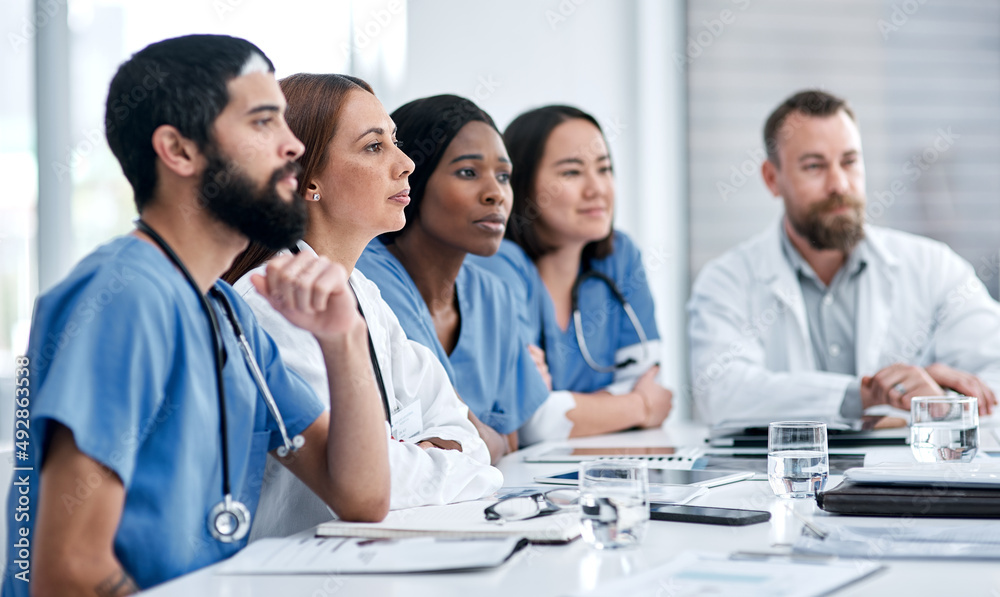 Working together to plan a patients care. Shot of a doctor sitting alongside her colleagues during a