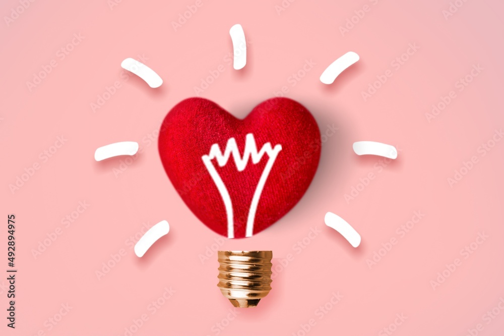 Light bulb icon on red heart. Love, care, sharing, giving, wellbeing, inspiration, and idea concepts