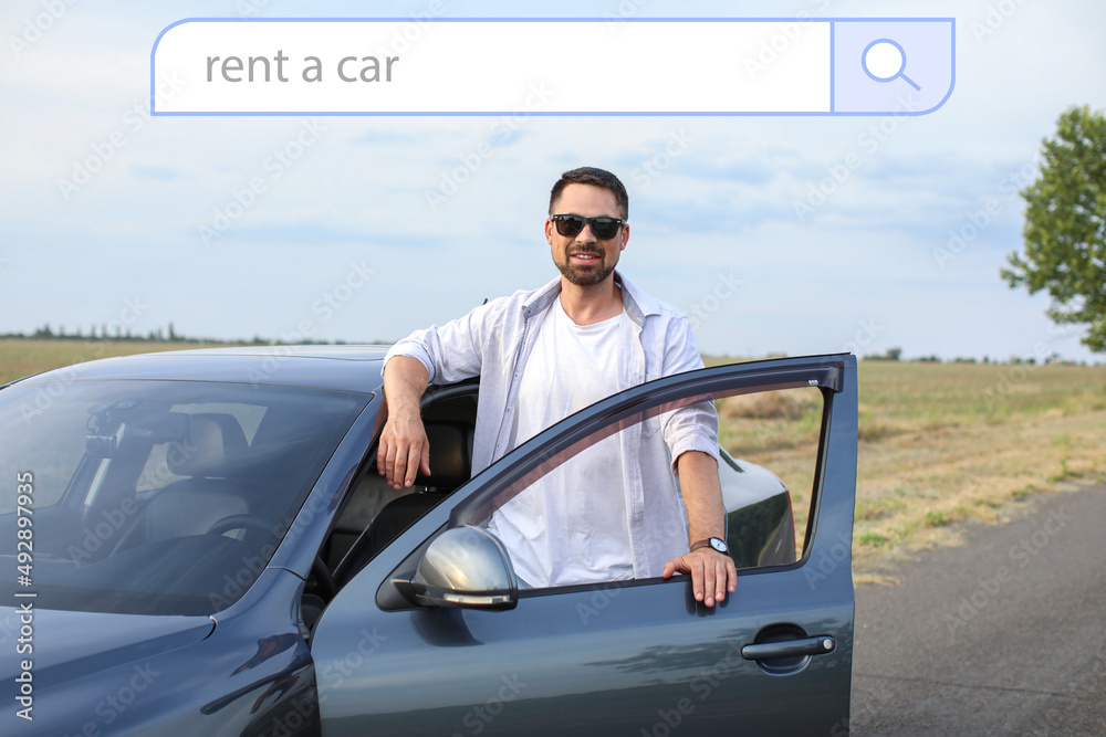 Handsome man near his modern automobile outdoors. Rent car