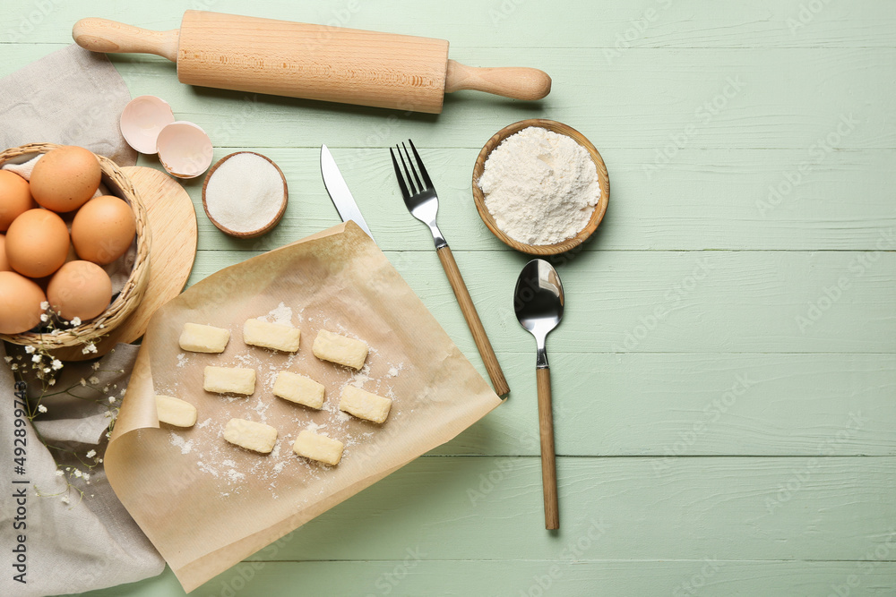 Raw lazy dumplings and ingredients on color wooden background