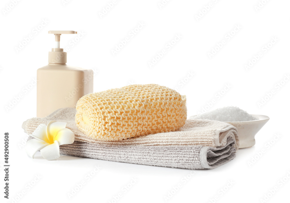 Bottle of cosmetic product, sea salt, towels and bath sponge on white background