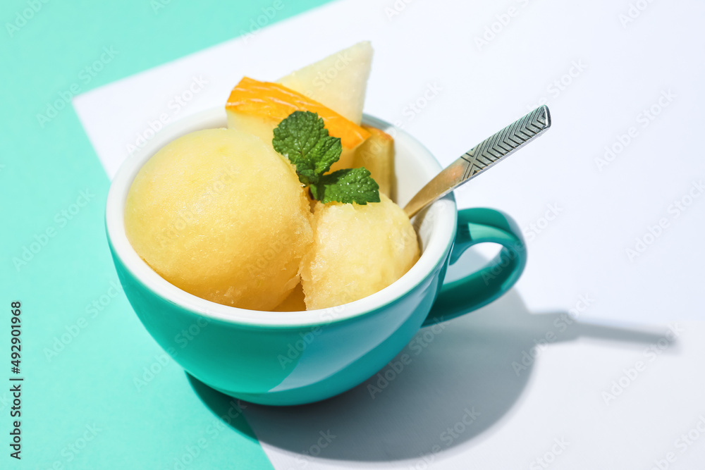 Cup with tasty melon sorbet on color background